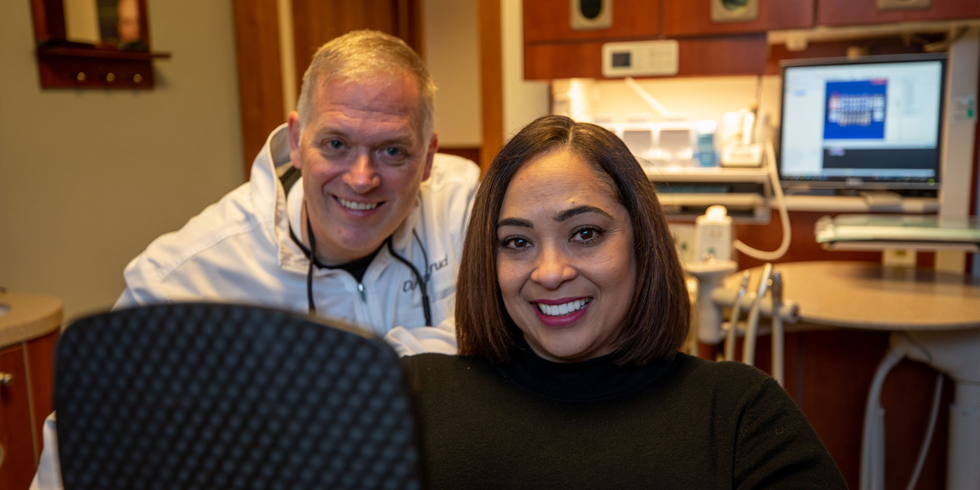 Doctor and patient smiling confidently after their dental procedure