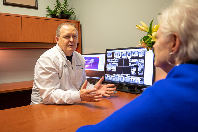 Doctor and patient discussing over dental procedure information