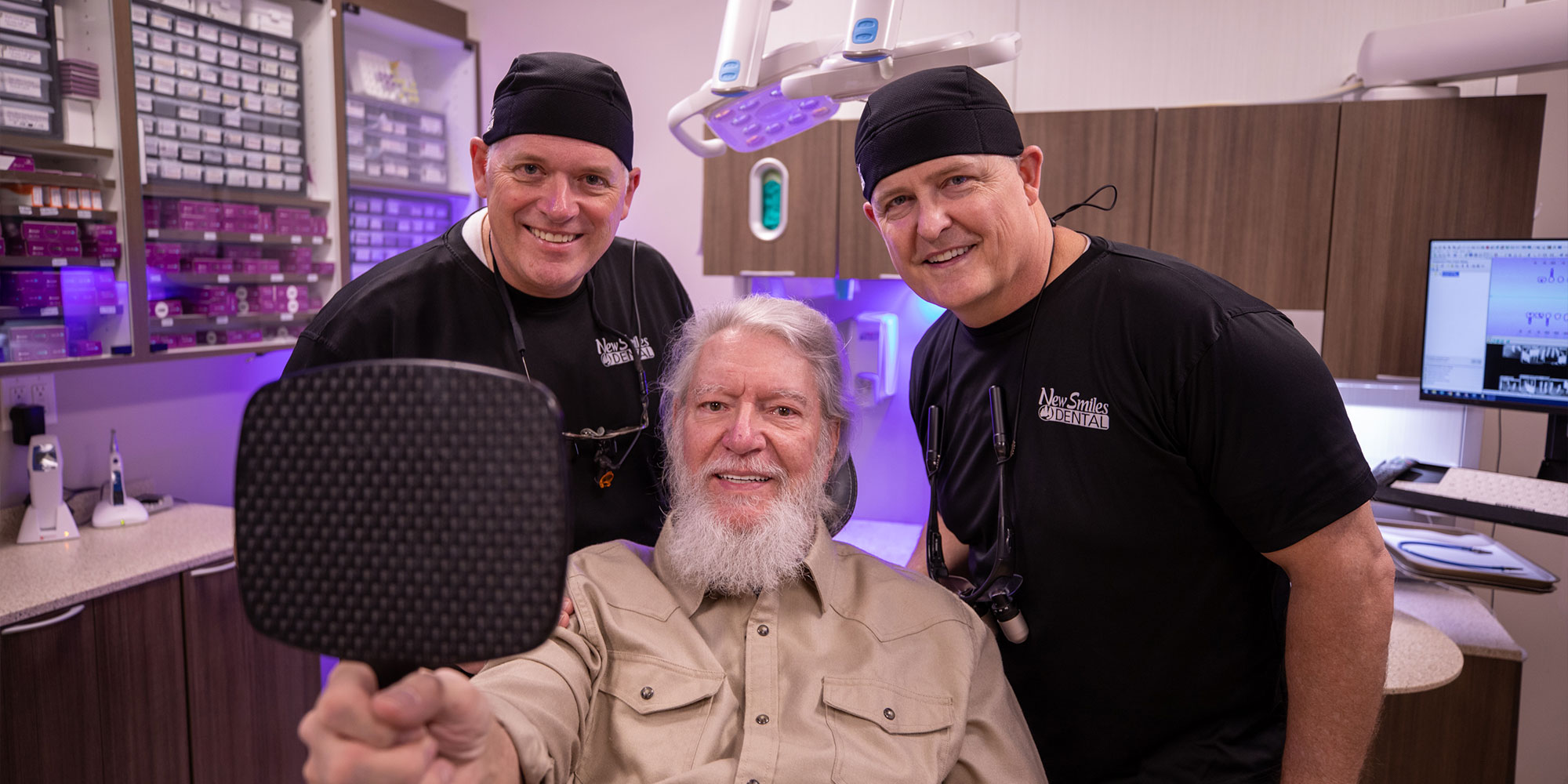 Patient and doctors smiling after dental procedure