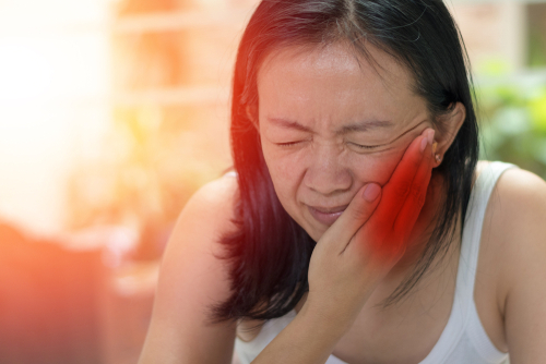 woman hand on cheek face as suffering from facial pain, or toothache